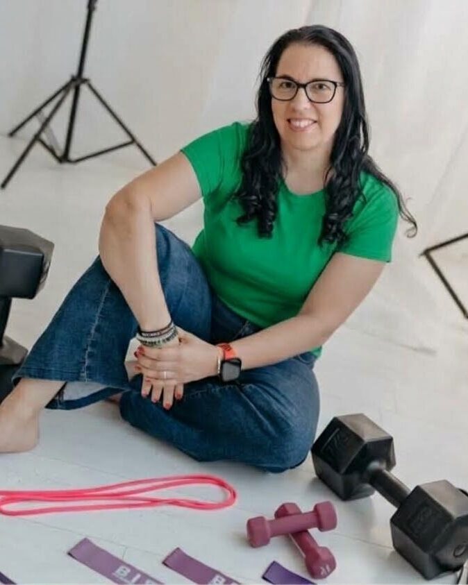 Aniko Sánta-Kisfalvi sitting on the floor with her weights and resistance bands