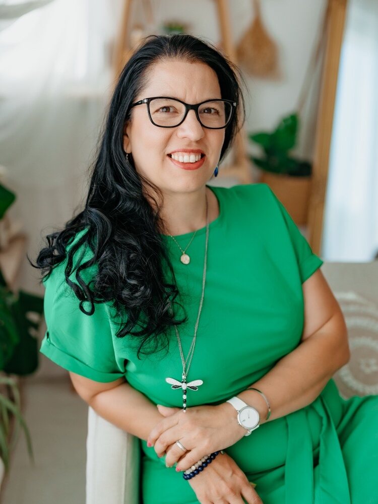 Aniko Sánta-Kisfalvi, seated, in an emerald dress